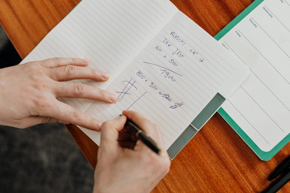 Persona che scrive su un taccuino durante una sessione di brainstorming strategico